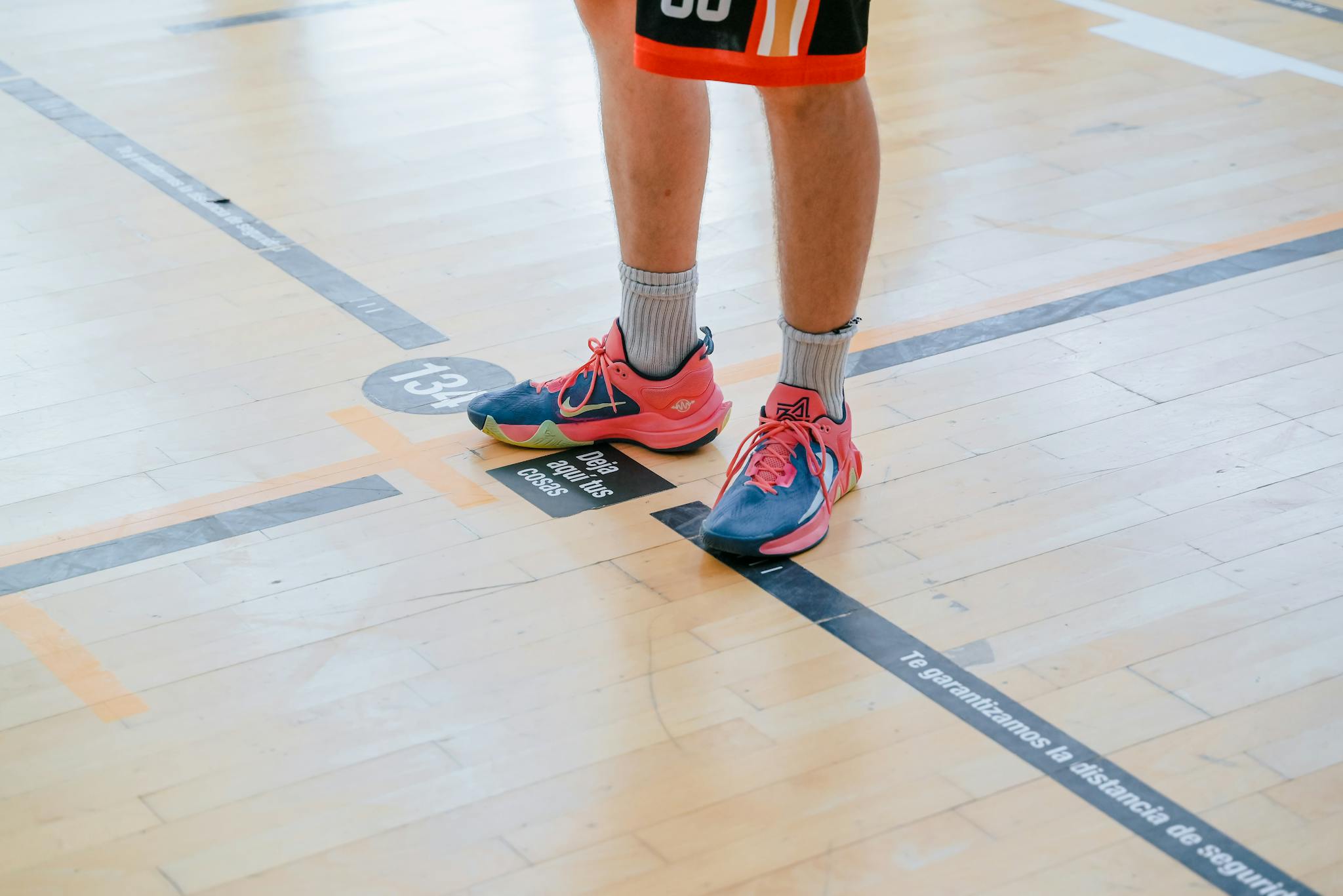 A person standing on a basketball court with their feet