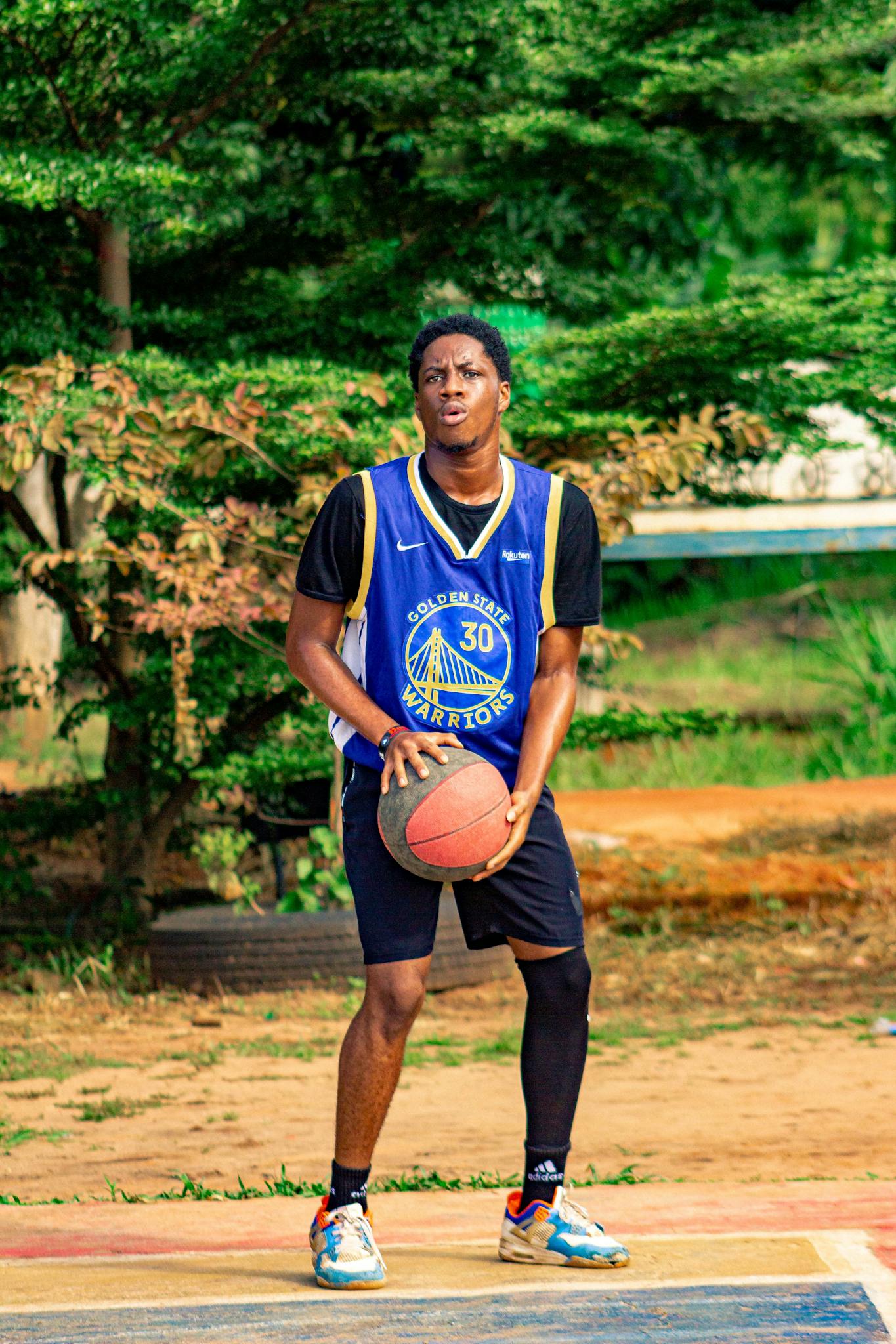 A young man in blue and black uniform holding a basketball